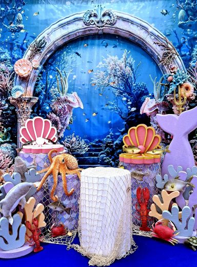 Unterwasser-Szene mit Muscheln, Korallen und einem weißen Vorhang in der Mitte.
